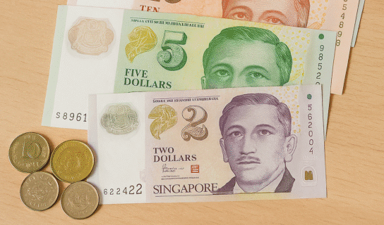 Billetes y monedas del dólar de Singapur sobre una mesa